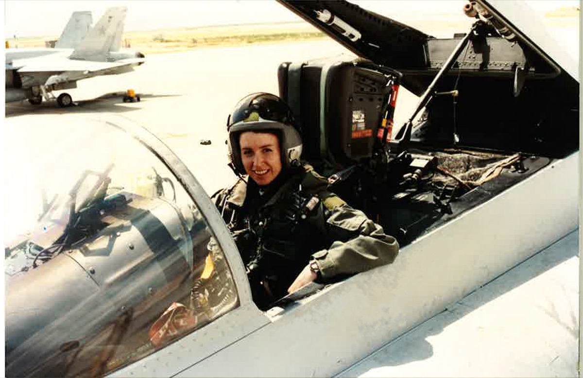 A young Loree Draude in a jet cockpit on the flight line during her Navy years